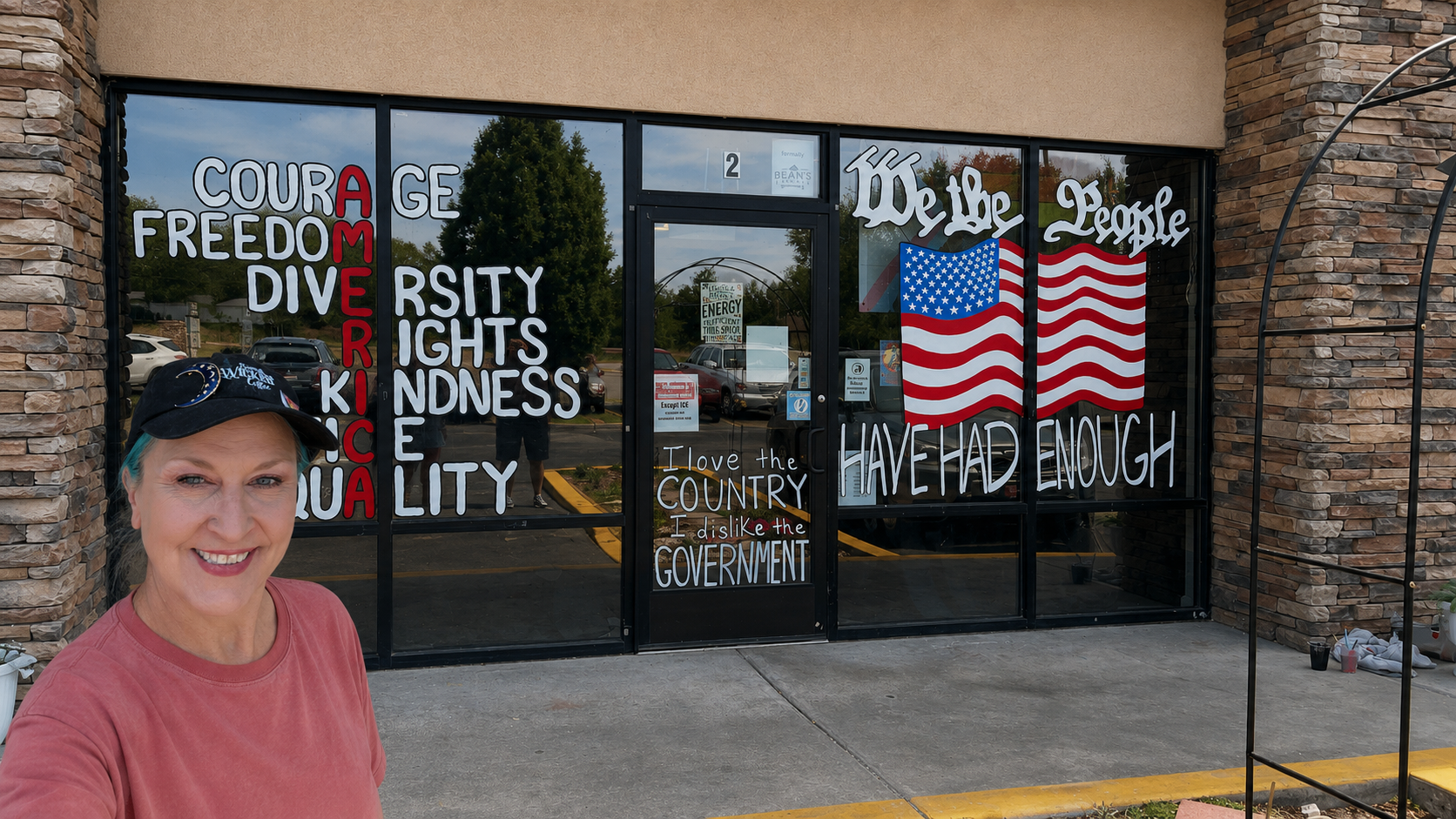 Owner in front of the Something Wicked Coffee storefront window art